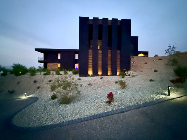 Exterior painting and finish work on a modern home at dusk